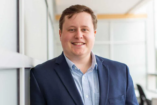 Ian Steenstra smiling in a navy blazer and light blue shirt